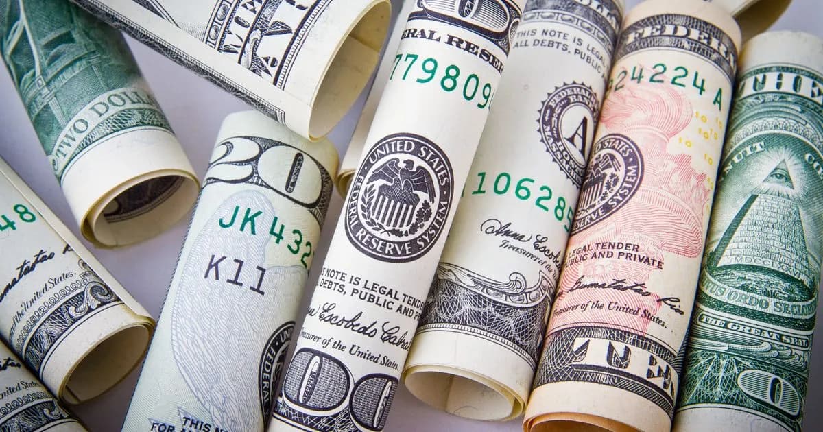 US dollar banknotes fanned out on a surface, representing USD to IDR currency exchange for Bali travel